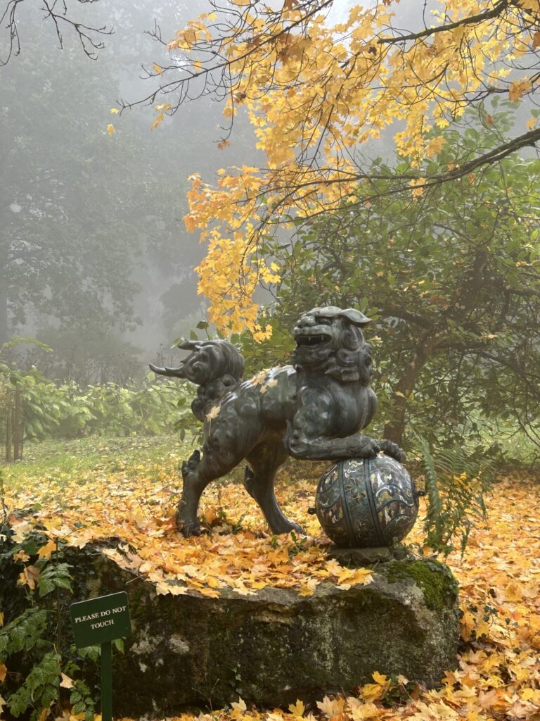 Batsford arboretum - a mythical beast called Foo Dog with its paws raised on a on a cloisonné enamelled globe
